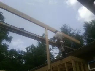 Carpenter setting a ridge beam over a new addition frame — Ice Dam Removal by Roofing Brothers in Pleasureville
