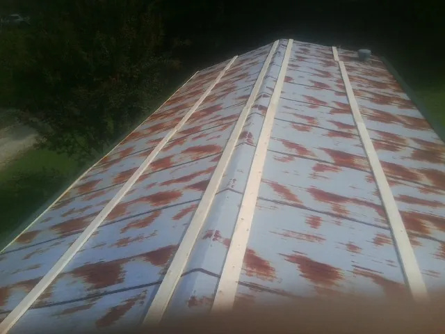 Rusted metal roof panels with new wood purlins before replacement — Storm Damage Roof Repair in Pleasureville by Roofing Brothers