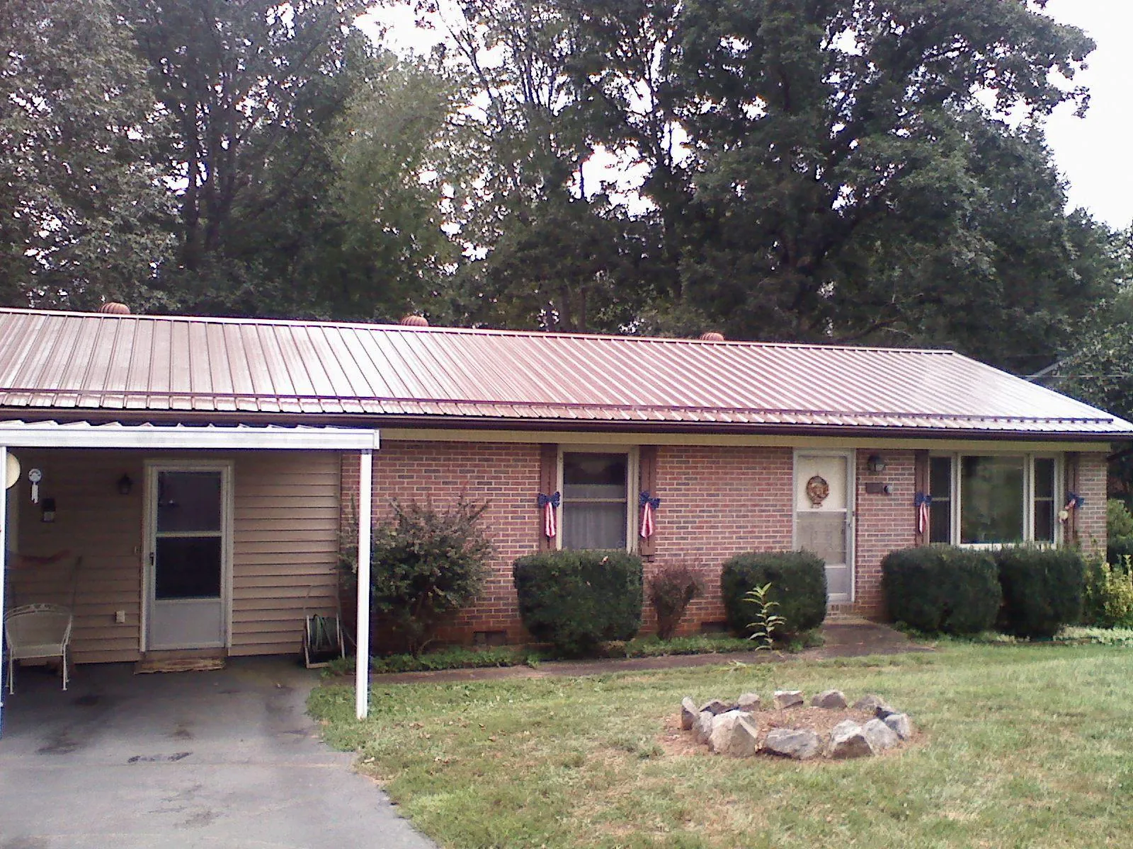 Bronze metal roof and carport on a brick ranch home — Roof Repair work by our crew in Pleasureville